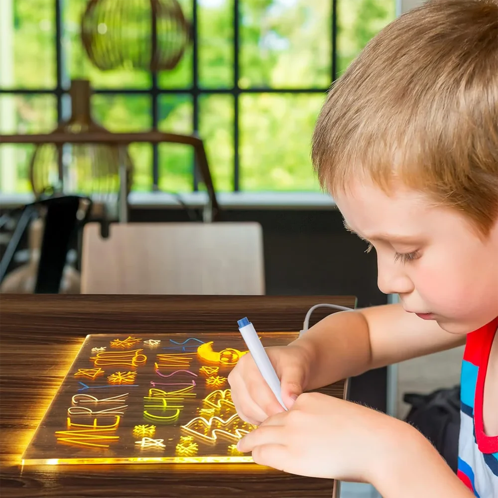 Child writing on a light-up board with colorful letters in a classroom setting