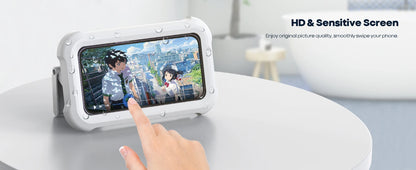 Hand interacting with a handheld device displaying an animated scene on a white surface.