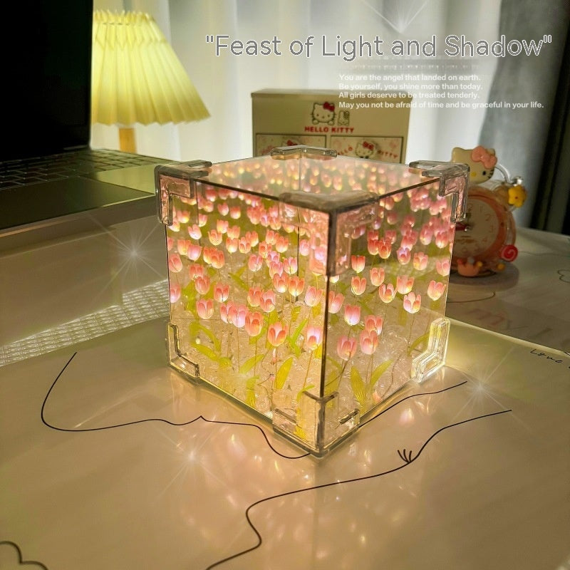 Decorative light cube on a desk with a laptop and stationery items in the background.