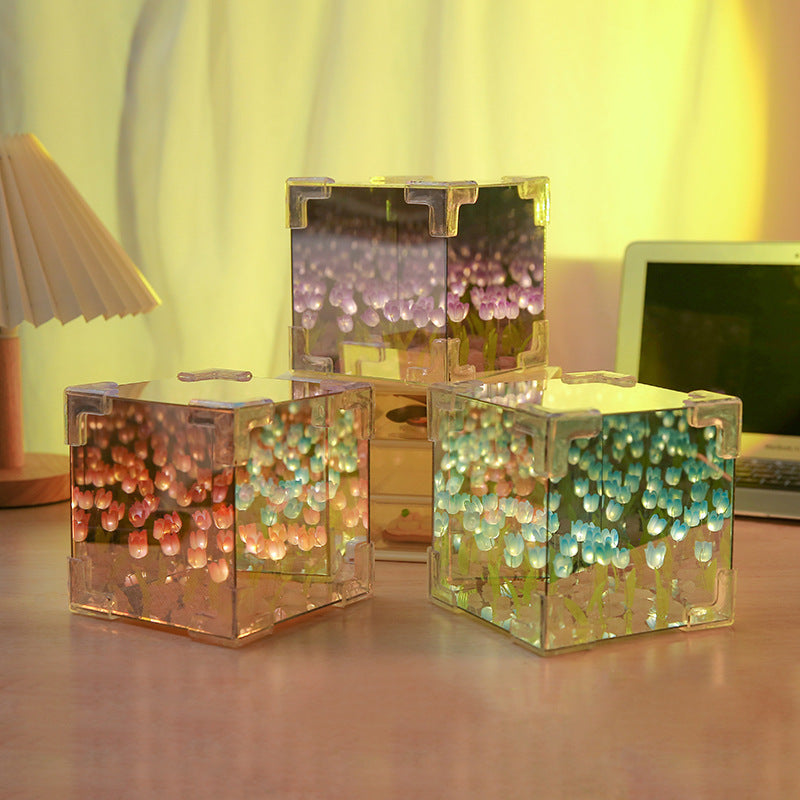 Three transparent cube containers with colorful beads on a desk.